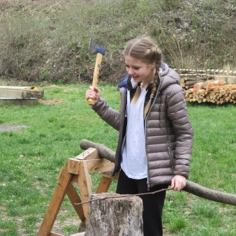 i ragazzi mentre tagliano la legna con degli strumenti